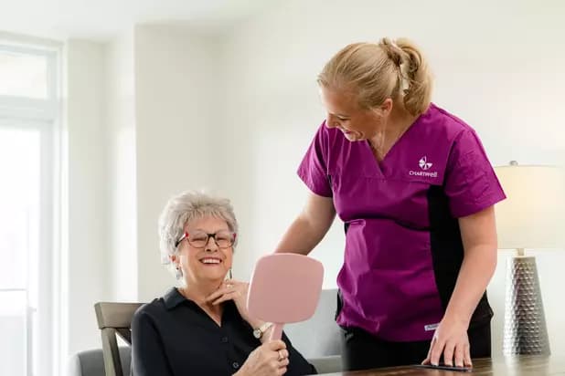 Chartwell care staff helping the senior resident grooming her hair