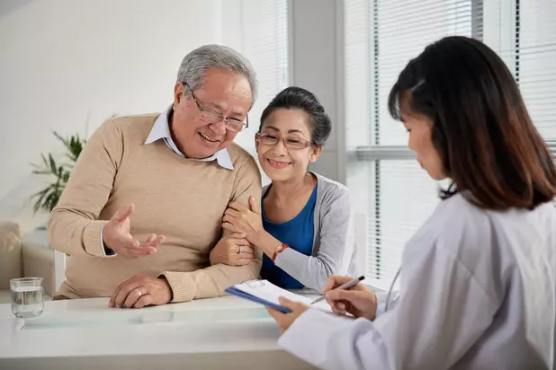 Senior couple meeting with a healthcare professional to review care options / Couple d’aînés rencontrant un professionnel de la santé pour examiner les options de soins