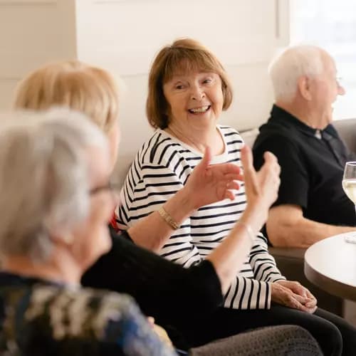 Senior residents chatting and enjoying a glass of wine
