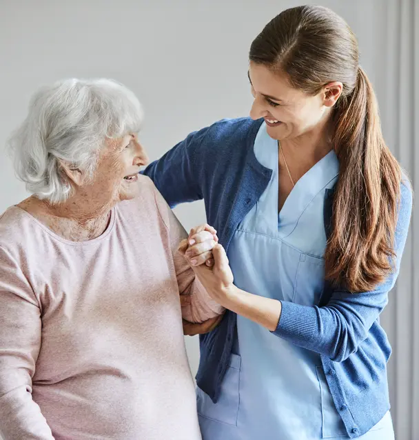 Care giver gently guides senior woman with a kind smile / L'aide-soignante accompagne délicatement la personne âgée avec un sourire bienveillant