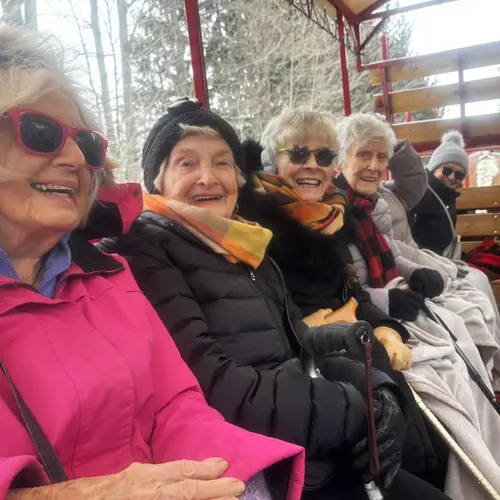 Residents sitting together on an outdoor wagon ride / Résidents assis ensemble lors d’une promenade en chariot extérieur