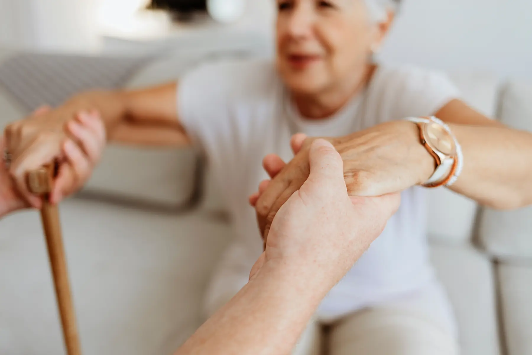 Senior woman getting a help from a care giver to stand up / Une femme âgée reçoit l'aide d'un soignant pour se lever