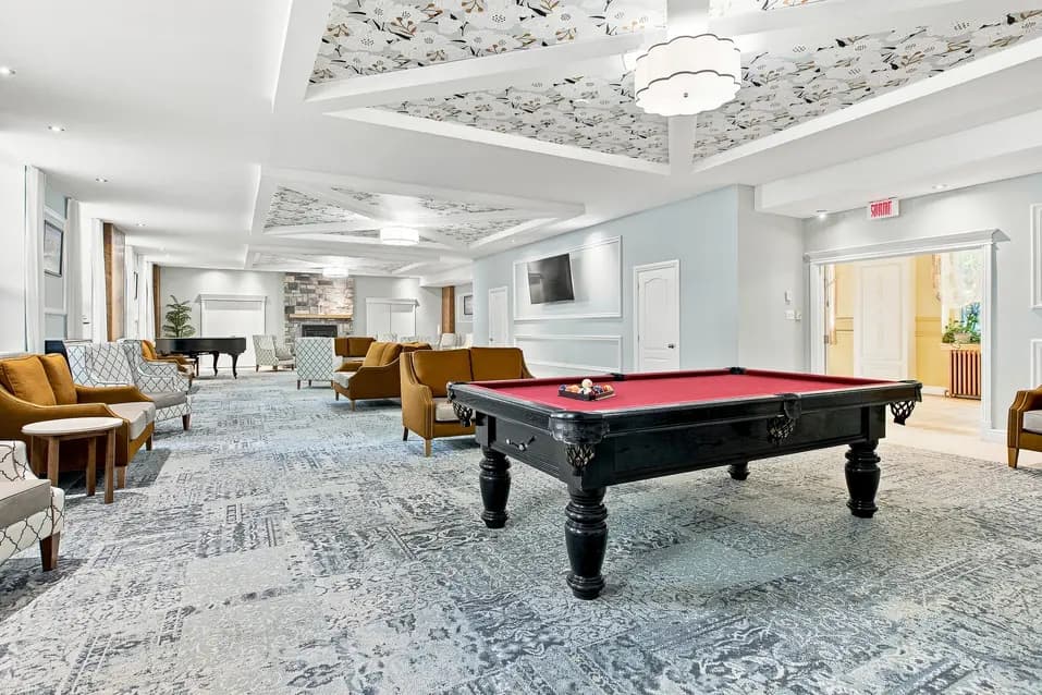 Salon commun avec table de billard et fauteuils confortables au Chartwell Monastère d'Aylmer. / Resident lounge with billiards table and comfortable seating at Chartwell Monastère d'Aylmer.