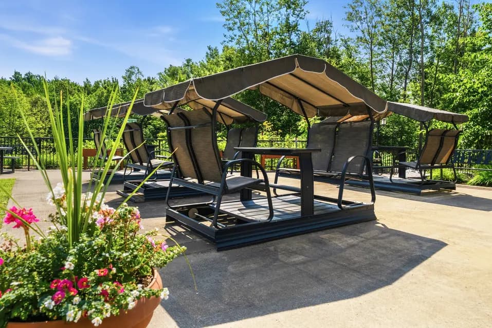 Terrasse extérieure avec balançoires et jardin paysager à Chartwell Des Rivières / Outdoor patio with canopy swings and landscaped garden at Chartwell Des Rivières