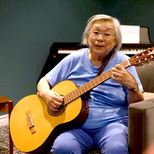 Senior woman is playing guitar / Une femme âgée joue de la guitare