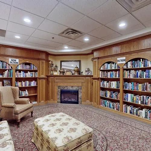 Library with couch and wingback chair at Chartwell Amherstburg
