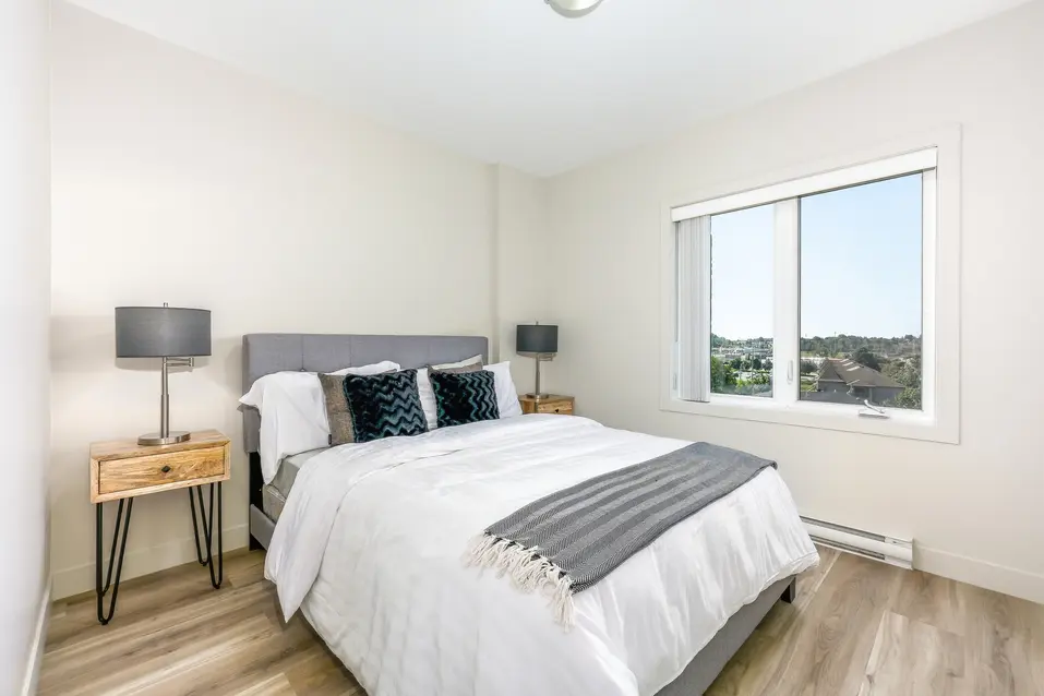 Chambre lumineuse avec lit double et grande fenêtre à Chartwell Des Rivières / Bright bedroom with double bed and large window at Chartwell Des Rivières
