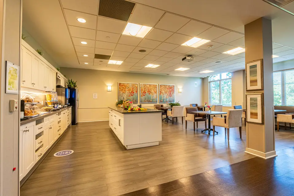Chartwell Palermo Village coutry kitchen. Kitchen counter located to the left, island in the middle, table and chairs to the right.
