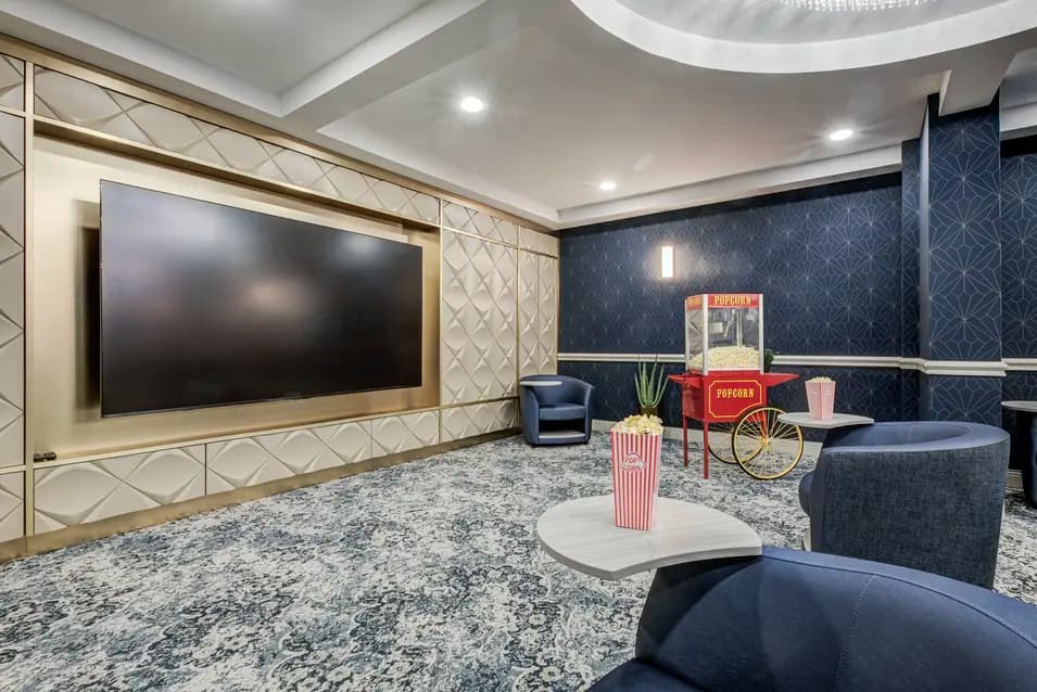 Private movie theatre with large screen and lounge seating at Chartwell ValleyVista / Salle de cinéma privée avec grand écran et fauteuils confortables à Chartwell ValleyVista