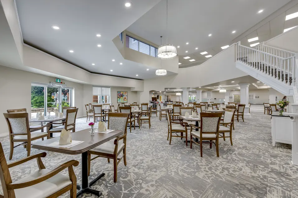 Bistro lounge with café tables and social seating at Chartwell Welland / Bistro avec tables de café et espace de rencontre à Chartwell Welland