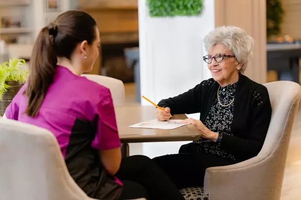 Chartwell staff chatting with the senior resident / Le personnel de Chartwell discute avec la résidente âgée