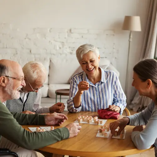 Seniors sitting at a table playing a game together