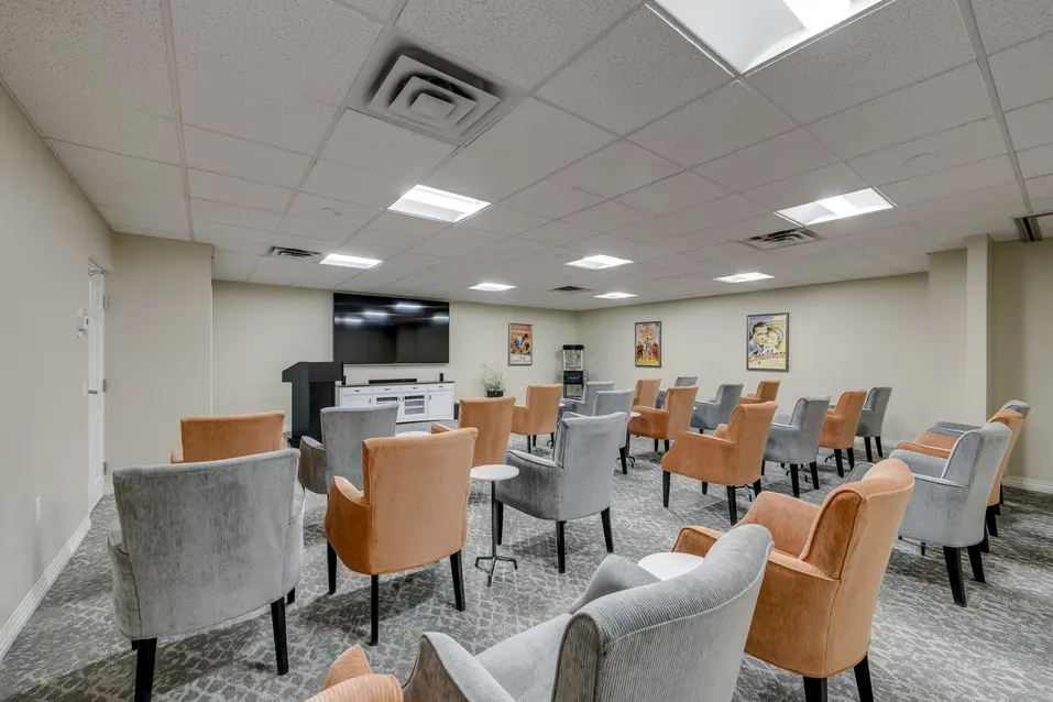 Movie theatre with lounge seating and entertainment space at Chartwell Welland / Salle de cinéma avec fauteuils de détente et espace de divertissement à Chartwell Welland