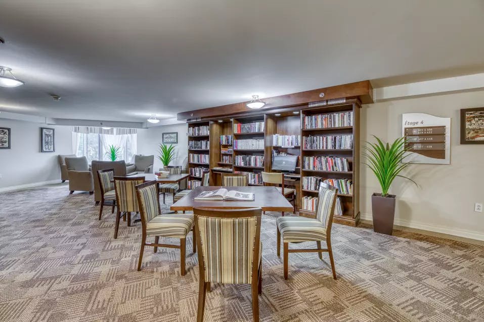 Bibliothèque commune  avec tables et chaises Chartwell Villa Rive-Sud résidence pour retraités