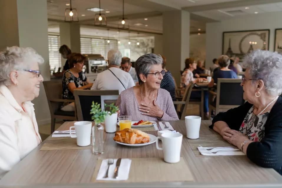 Chartwell senior resident chatting and enjoying food
