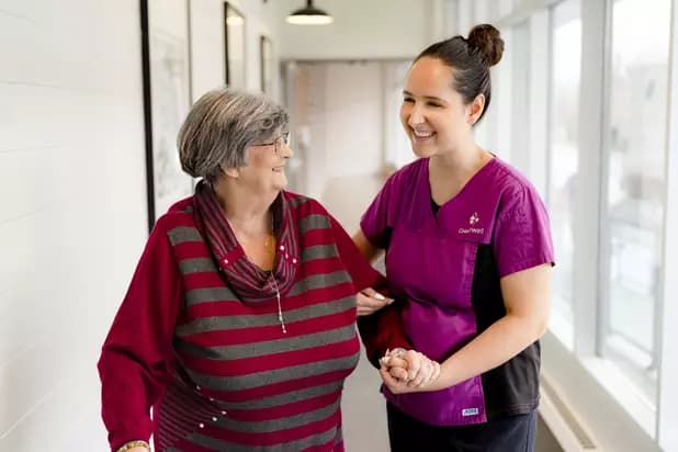Chartwell Care staff walking with the senior resident