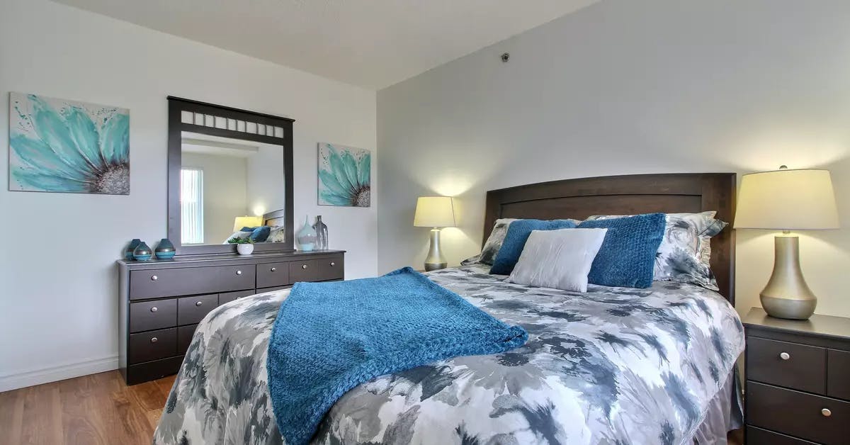 Chambre d'un appartement modèle avec grand lit Chartwell Villa Saguenay résidence pour retraités