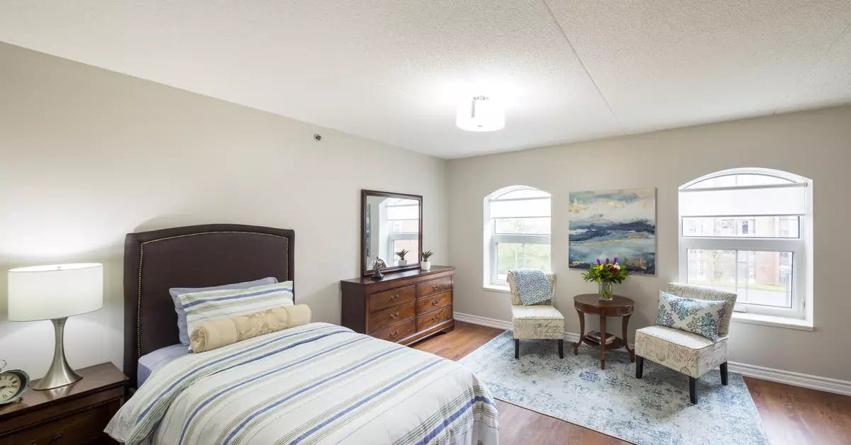 Chartwell Martha's Landing Retirement Residence bedroom with seating and lovely natural light