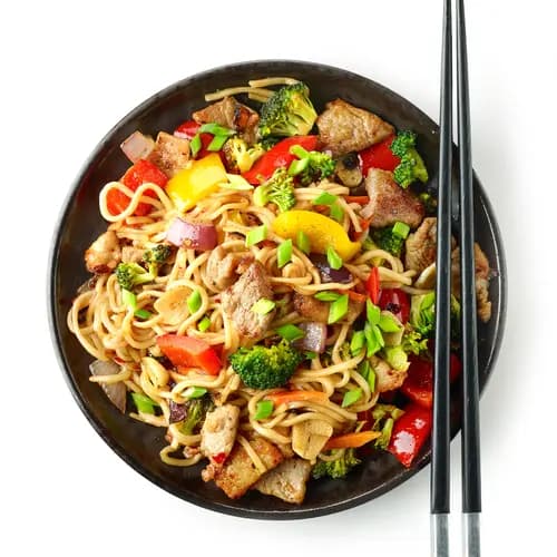 Plate of noodles with meat and vegetables with chopstick