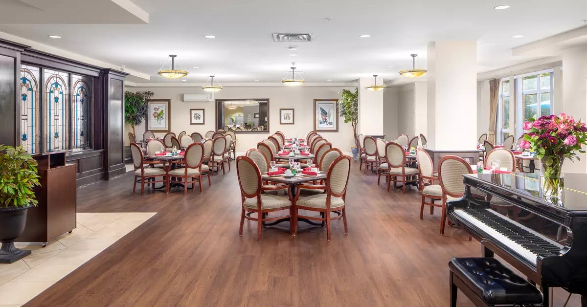 Gorgeous open concept dining room with piano at Chartwell Churchill House Retirement Residence