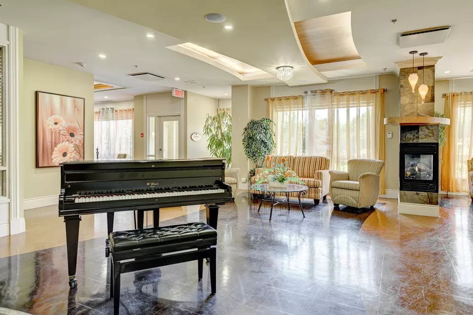 Salon commun avec foyer fauteuils et grand piano Chartwell Appartements de Bordeaux résidence pour retraités
