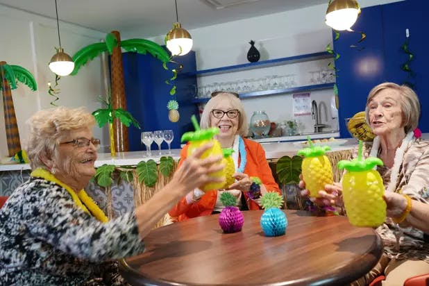 Senior ladies dressed up in Caribbean theme and enjoying drinks