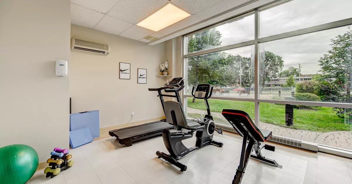 Salle de conditionnement physique avec équipement d'exercice chez Chartwell Belvédères de Lachine / Fitness room with exercising equipment at Chartwell Belvédères de Lachine