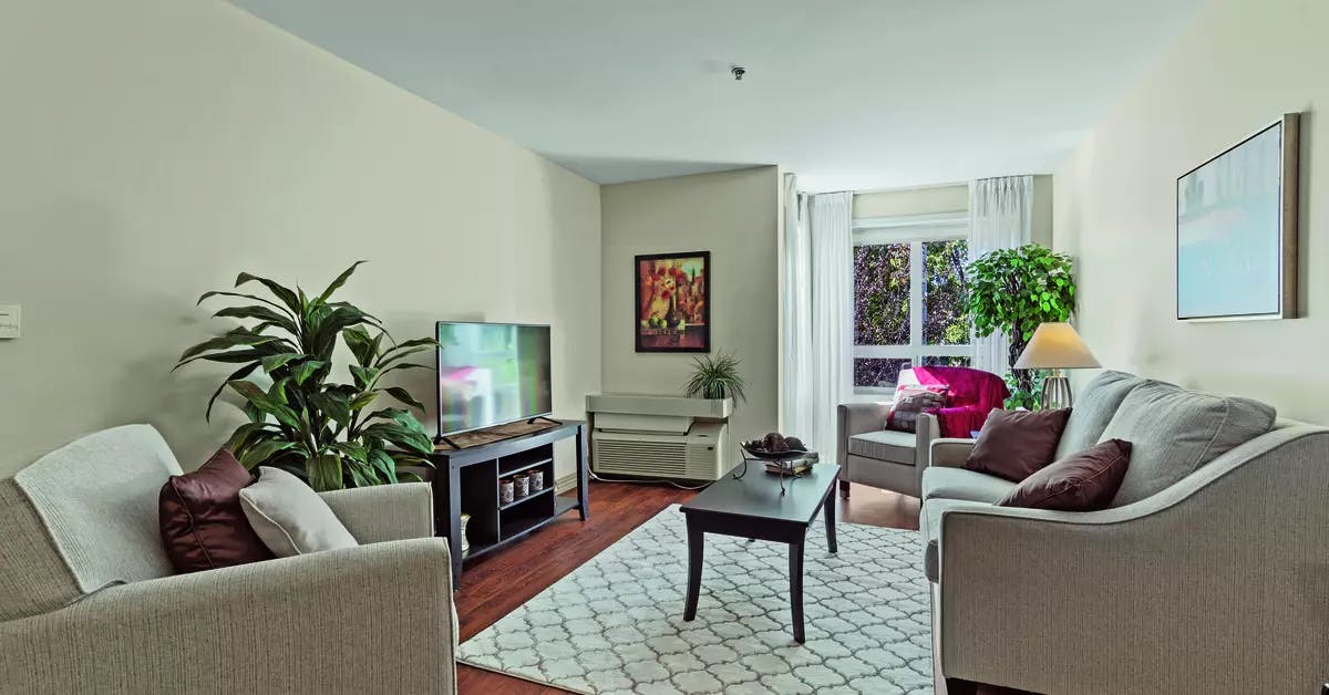 A illuminated spacious living room suite of Chartwell Isabella Retirement Residence  