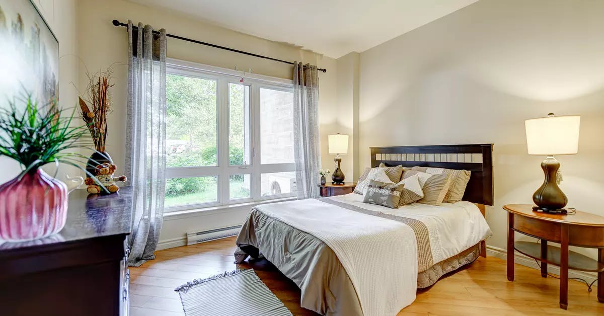 Chambre à coucher avec lit double bureau et grande fenêtre Chartwell Appartements de Bordeaux résidence pour retraités