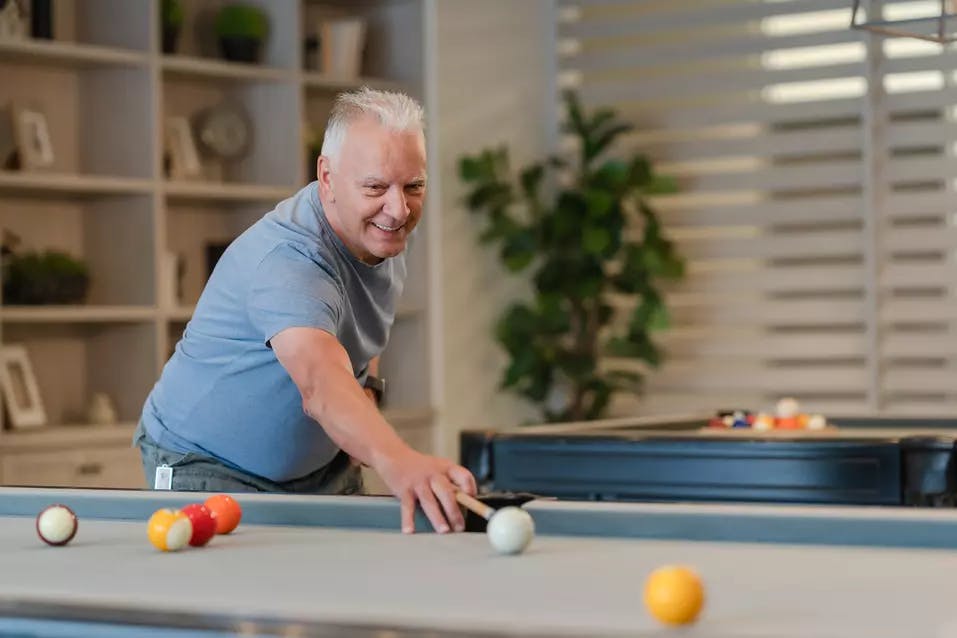 Senior resident enjoying the game of billiards in the activity room