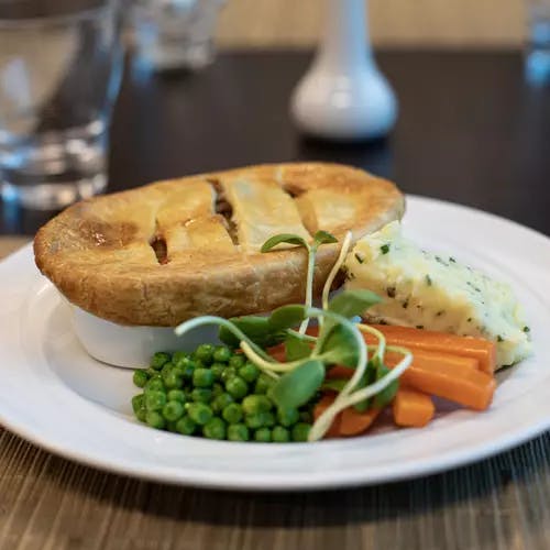 Chicken Potpie with mash potatoes, carrots and peas