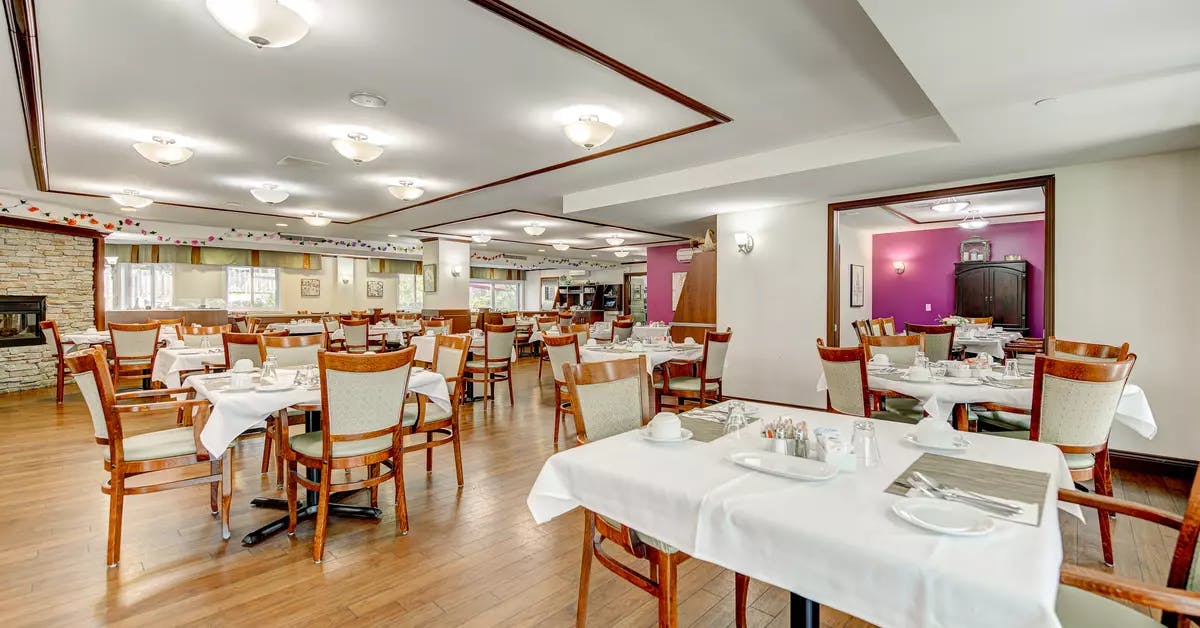 Salle à manger avec tables et chaises Chartwell Manoir Archer résidence pour retraités