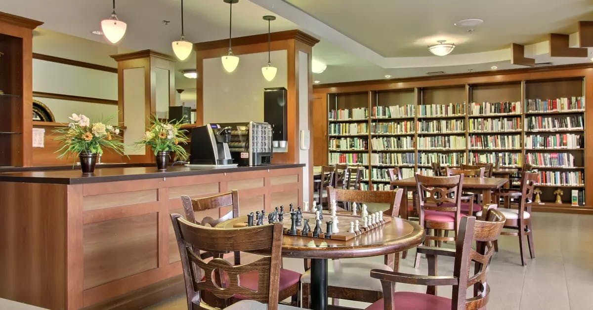 Bistro bibliothèque avec table de jeux Chartwell Faubourg Giffard résidence pour retraités