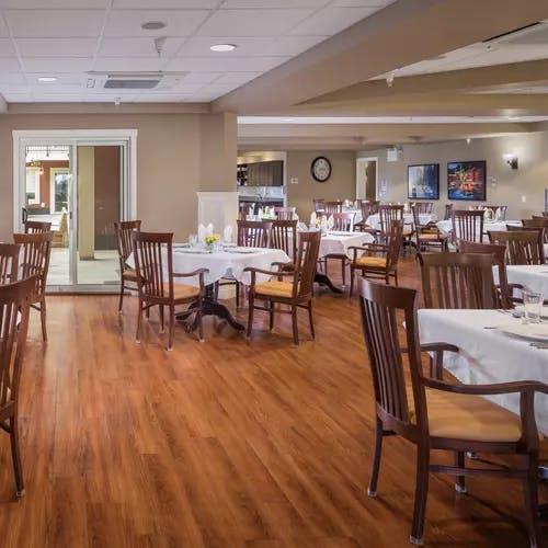 elegant dining room with white linens at chartwell ridgepointe retirement residence