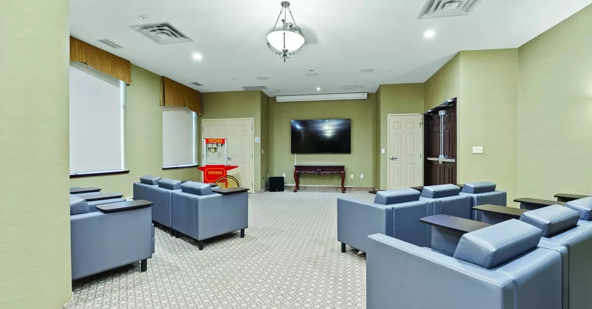 Chartwell Oakville Retirement Residence theatre with comfortable seas with side tables for snacks.