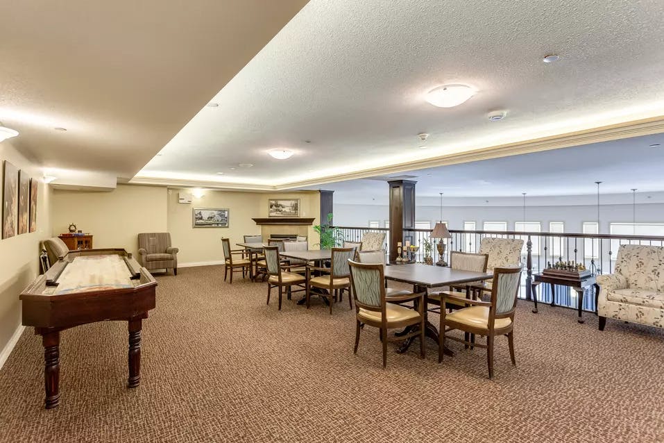 games room with shuffle board table at chartwell colonel belcher retirement residence