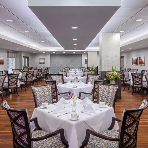 elegant dining with white linens at chartwell fountains of mission retirement residence