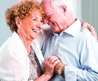 Senior couple holding each other close smiling