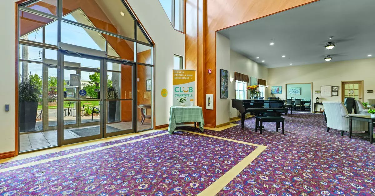 Grand entranceway with floor to ceiling windows at Chartwell Barton Retirement Residence.