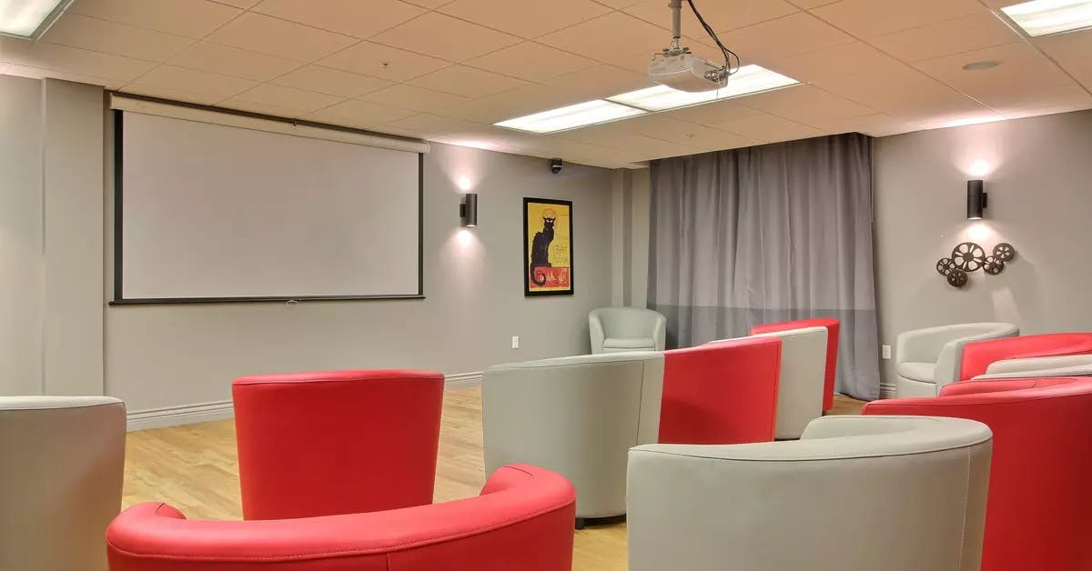Salle de cinéma avec fauteuils et écran de projection